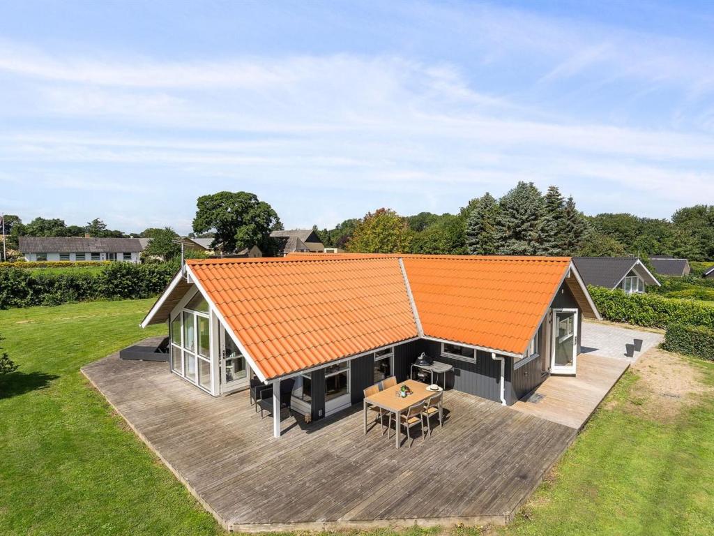 an orange roof on a house with a wooden deck at Holiday Home Aarne - 300m from the sea by Interhome in Sarup
