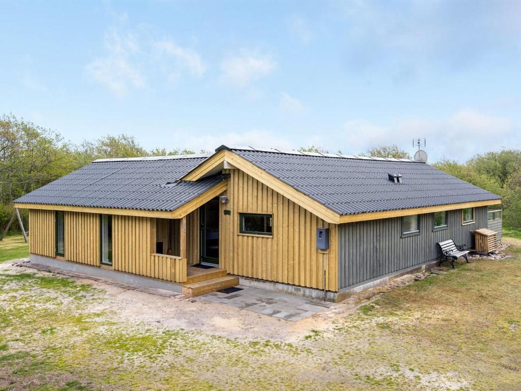 a house with a metal roof on a field at Holiday Home Arona - 1-5km from the sea by Interhome in Fanø