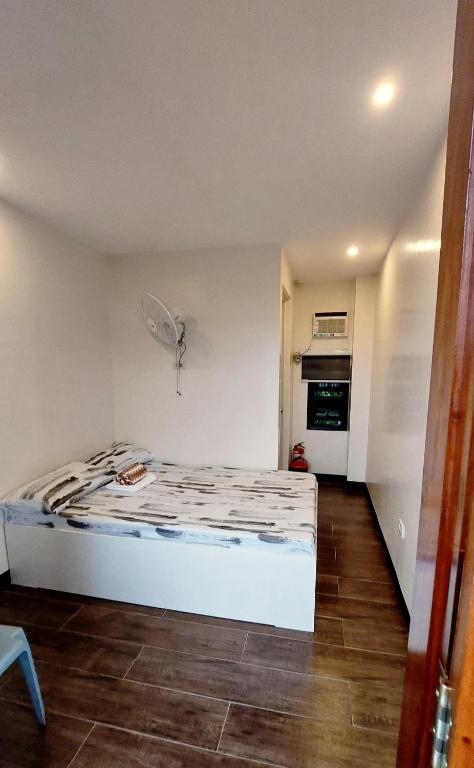 a small bedroom with a bed and a fan at Uno's Krib - Pilar in Pilar