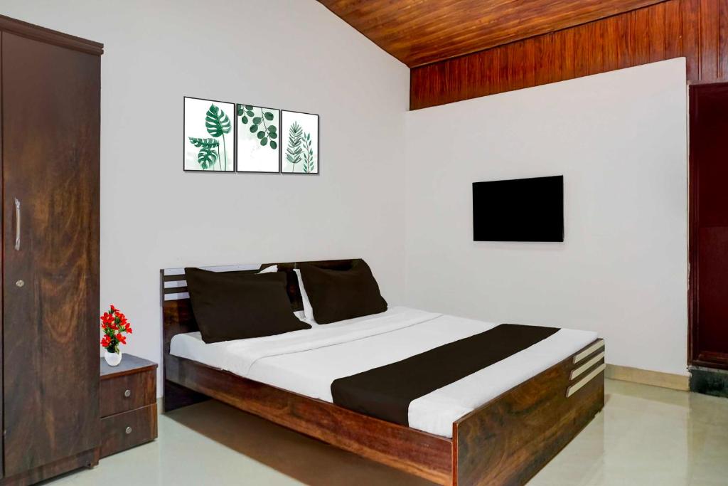 a bedroom with a bed and a tv at Collection O Malavli Lonavala Hill View in Lonavala