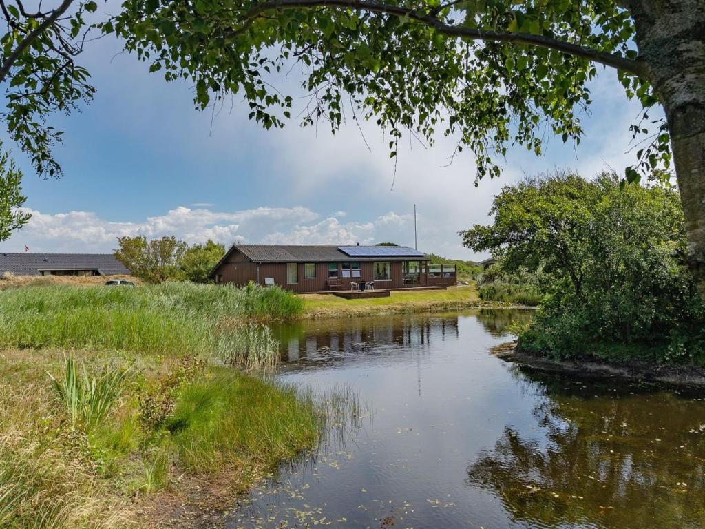 a house with a pond in front of it at Holiday Home Frigga - 400m from the sea by Interhome in Fanø