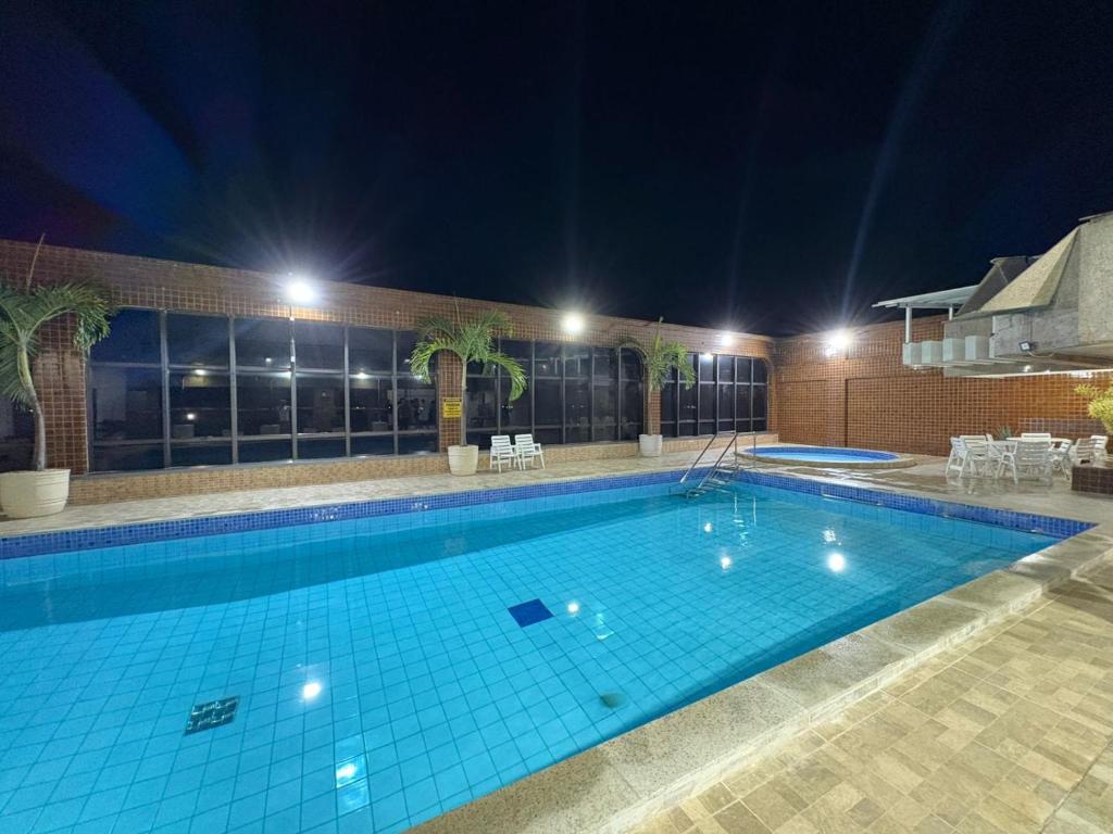 a large swimming pool at night at Sensacional Flat pé na areia na Praia da Costa in Vila Velha