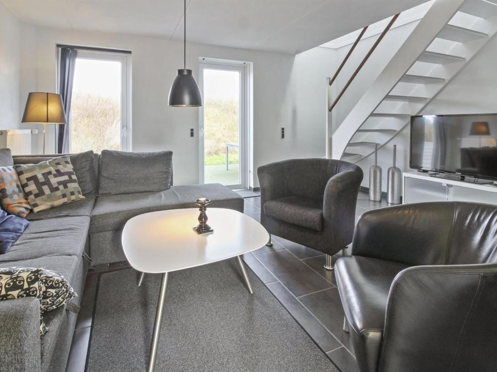 Una sala de estar con un sofá y sillas y una mesa. en Apartment Alvild - 2-3km from the sea by Interhome, en Sønderby