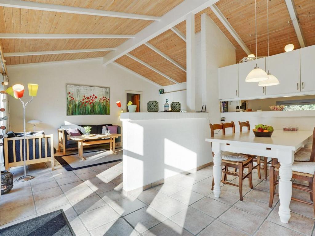 une cuisine et une salle à manger avec une table et des chaises blanches dans l'établissement Holiday Home Reinbald - 1km from the sea by Interhome, à Mølby