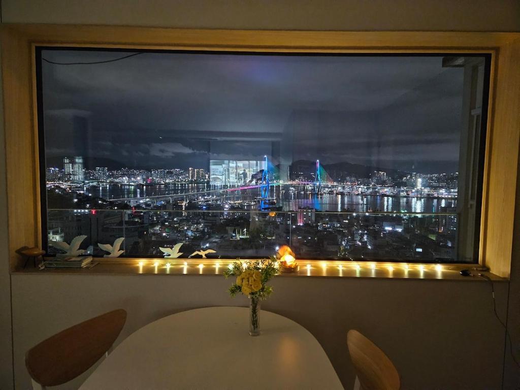 a window with a view of a city at night at Youngdo Blue Sky 