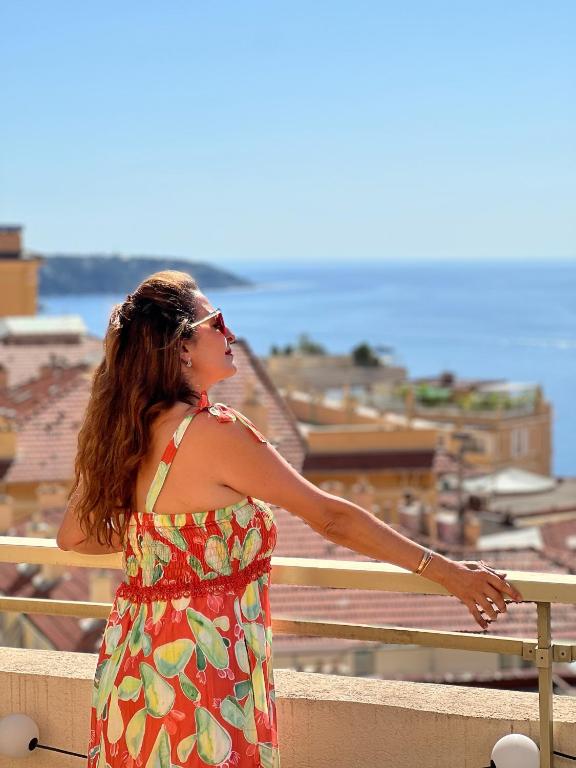 a woman in a dress looking out over a city at French Riviera - Monaco in Beausoleil