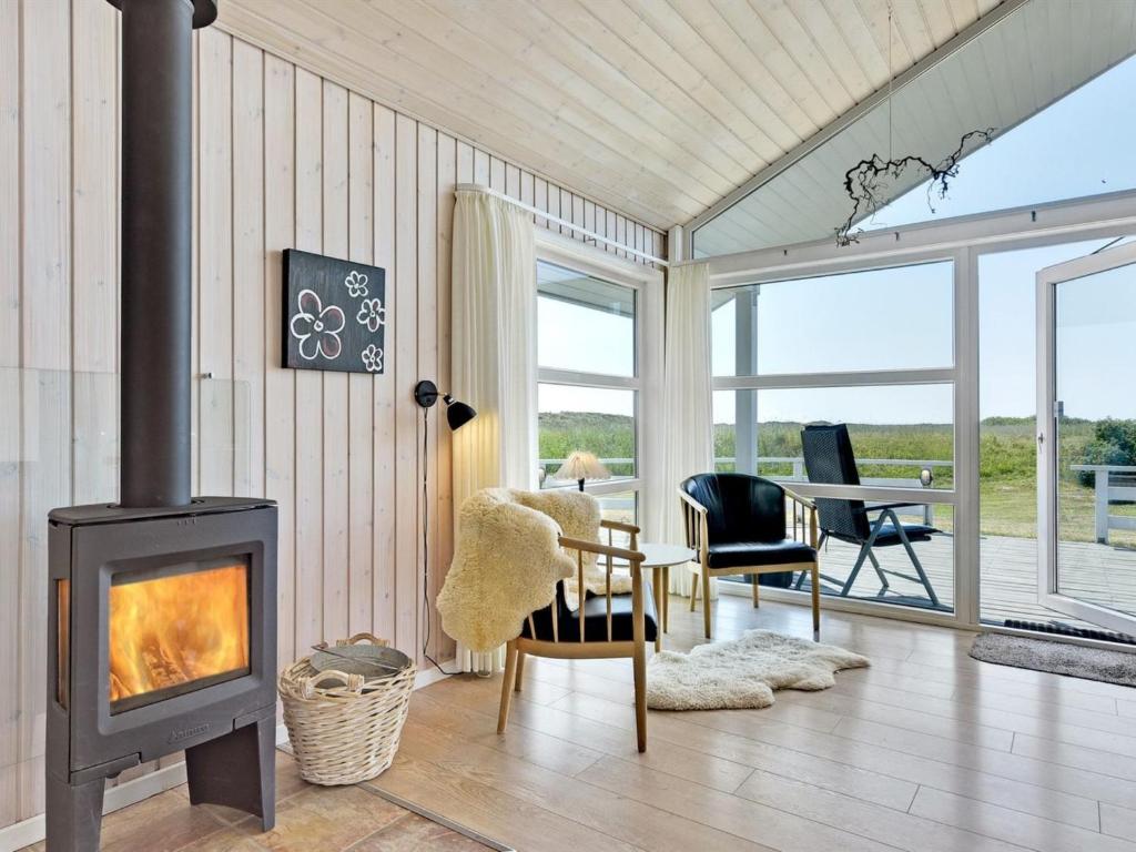 a living room with a wood stove and a table at Holiday Home Chrisse - 550m from the sea by Interhome in Lakolk
