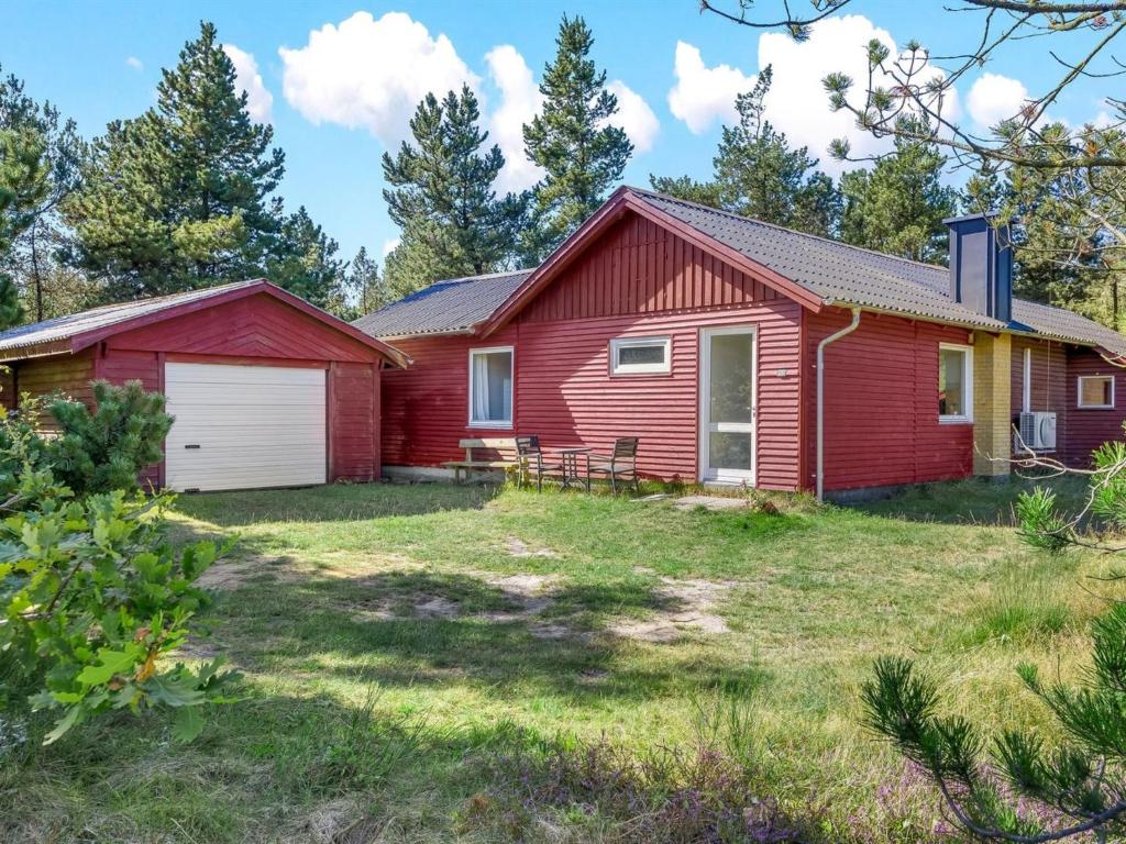 une maison rouge avec une cour devant elle dans l'établissement Holiday Home Dorreth - 800m from the sea by Interhome, à Mølby