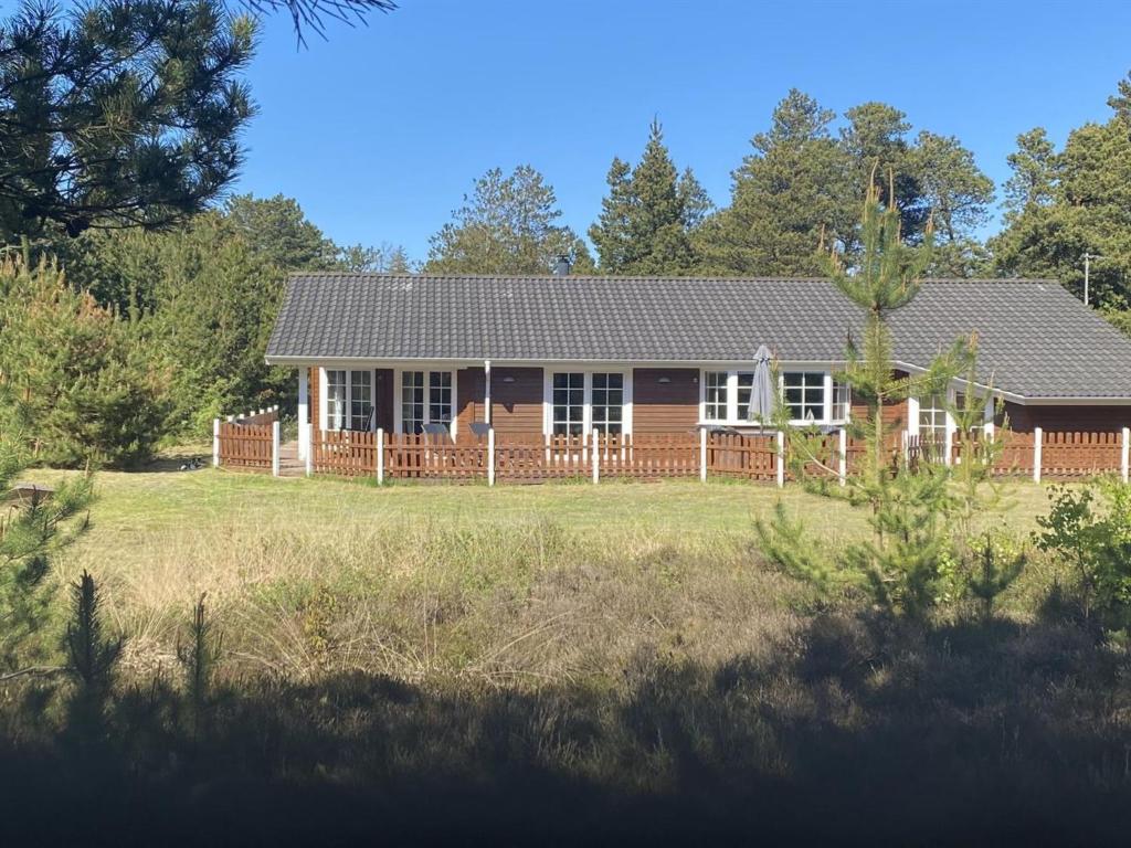 a house with a fence in a field at Holiday Home Orpah - 2-5km from the sea by Interhome in Kongsmark