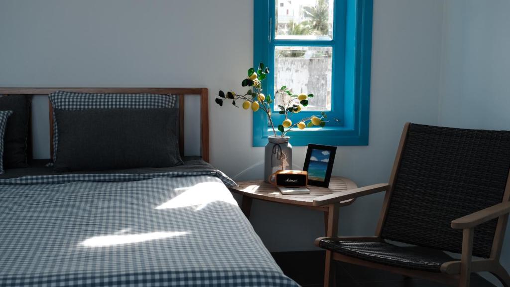 a bedroom with a bed and a table and a window at MayHome Binh Dinh in An Hòa