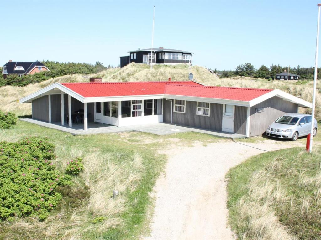 a house with a red roof on top of a hill at Holiday Home Dalia - 200m from the sea by Interhome in Vejers Strand