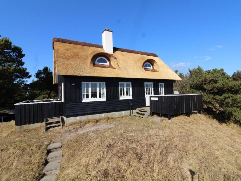 una casa negra en la cima de una colina en Holiday Home Erikke - 300m from the sea by Interhome, en Vejers Strand