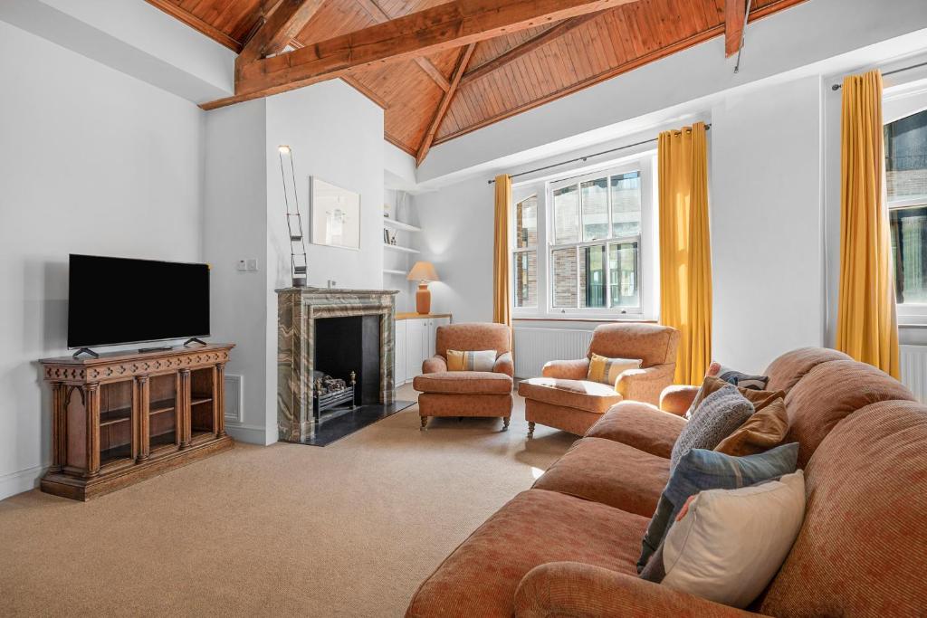 a living room with a couch and a tv at Luxury Spacious 3 Bedroom, 3 Bathroom Apartment, Walk to Soho, West End, Covent Garden, China Town, Piccadilly in Minutes, Complimentary Fast WiFi, Tea & Coffee in London