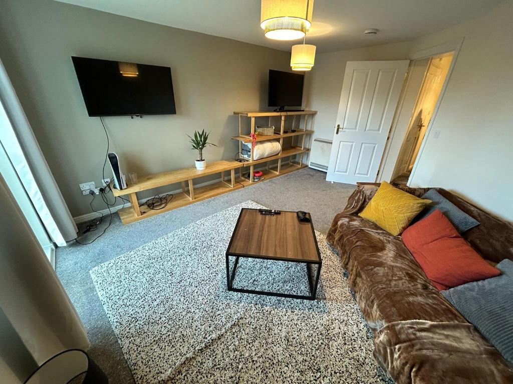 a living room with a couch and a table at Spacious 2-Bedroom Flat Near Shops & Transport in Newbury