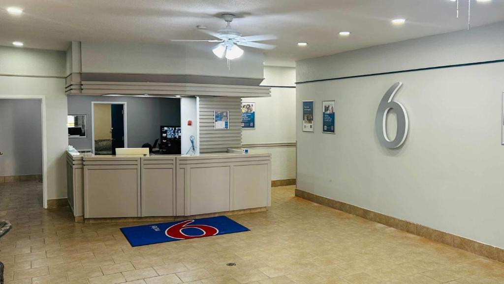 an empty lobby with a reception desk and a ceiling fan at Motel 6 Cornwall, ON in Cornwall