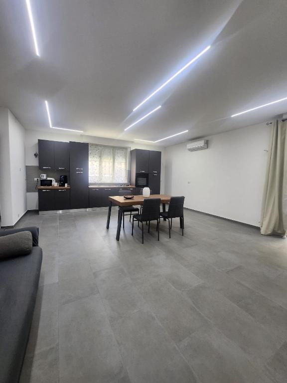 a room with a table and chairs and a kitchen at Naxos Blu Appartament in Giardini Naxos