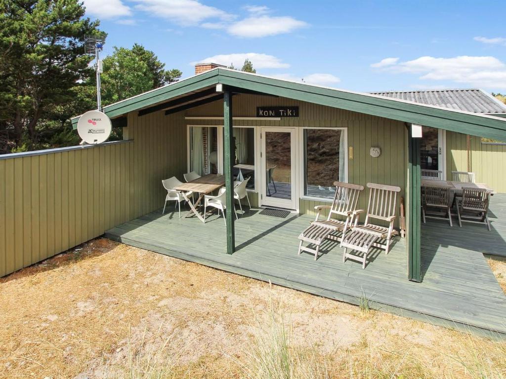 une maison dotée d'une terrasse avec des chaises et une table dans l'établissement Holiday Home Thurgot - 720m to the fjord by Interhome, à Bjerregård