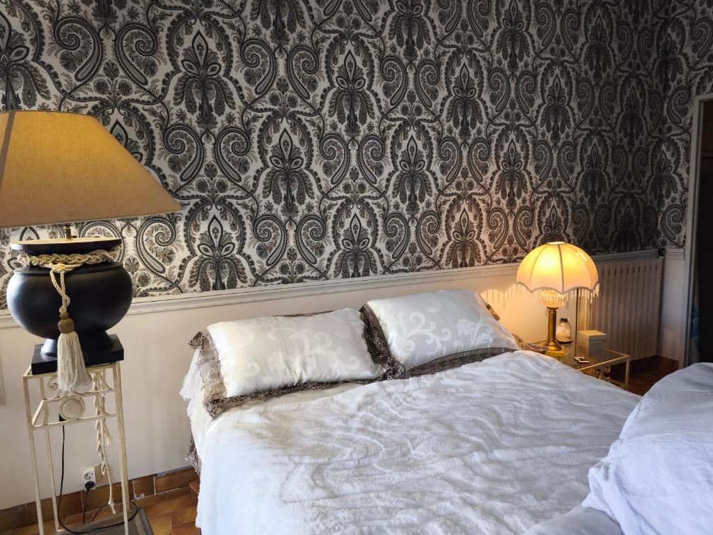 ein Schlafzimmer mit einem Bett und einer Tapetenwand in der Unterkunft Chambre d'hôte atypique in La Garde