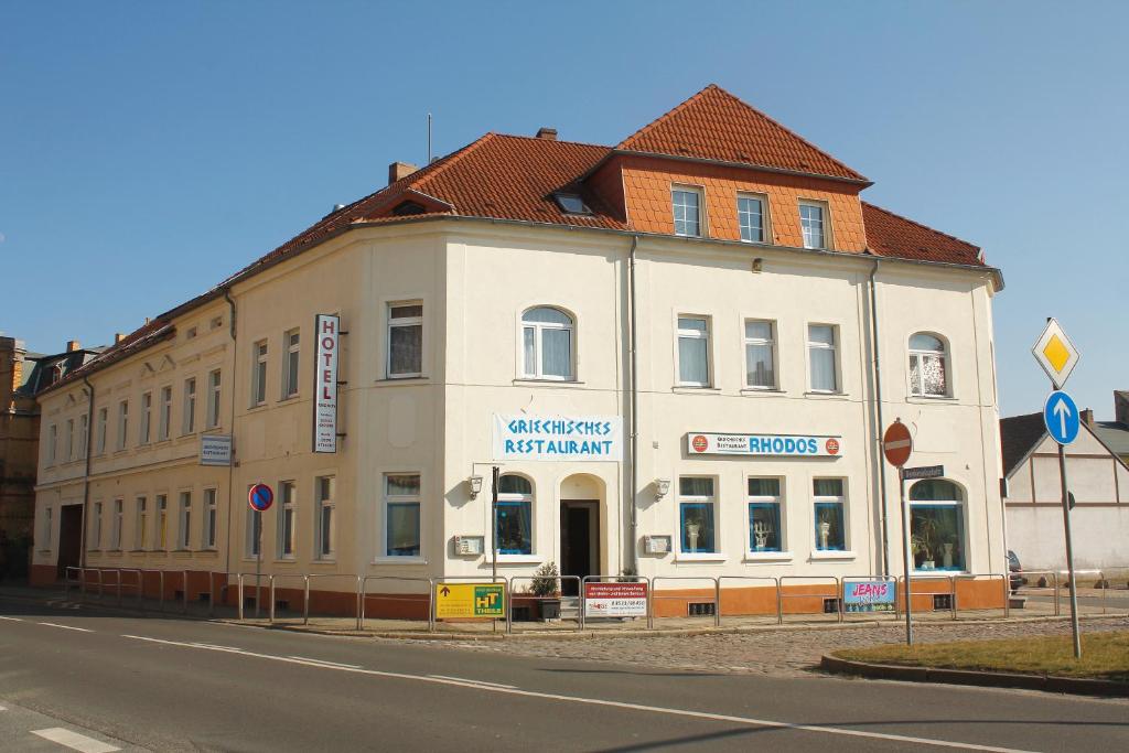 a large white building on the side of a street at Hotel Restaurant Rhodos in Elsterwerda