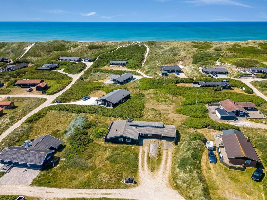 an aerial view of a property with the ocean at Holiday Home Temelko - 200m from the sea by Interhome in Hvide Sande