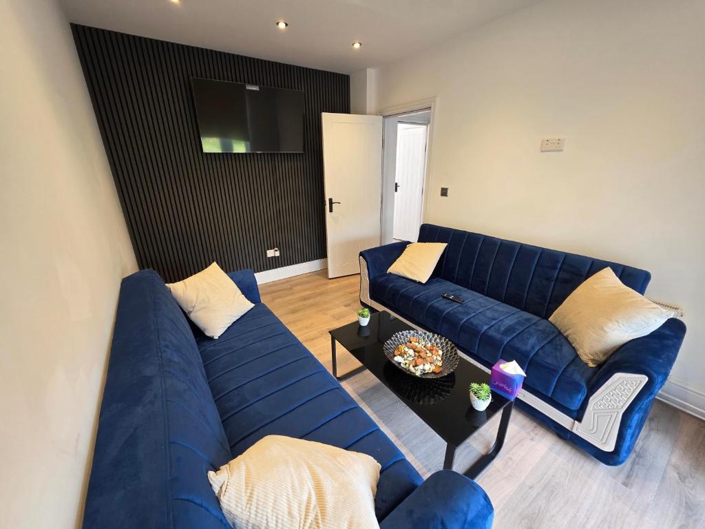 a living room with a blue couch and a table at 5 Beds 7 guests Private Garden Free Parking in Nottingham