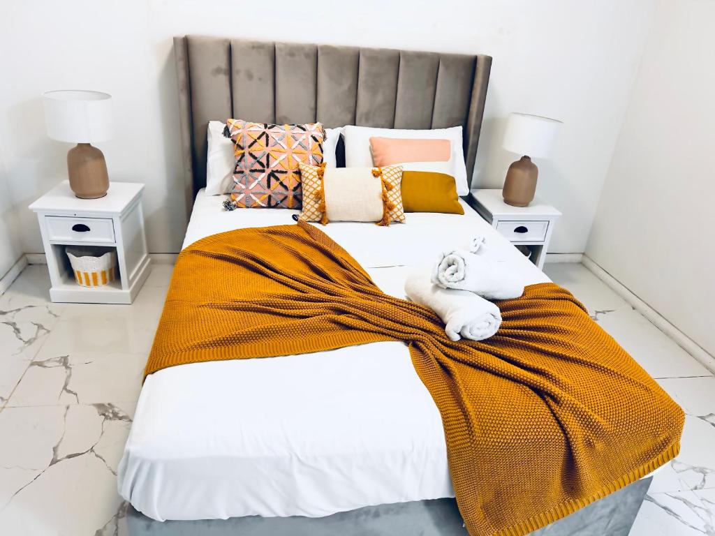a bedroom with two beds with an orange blanket at Harmony Accommodation in Townsville