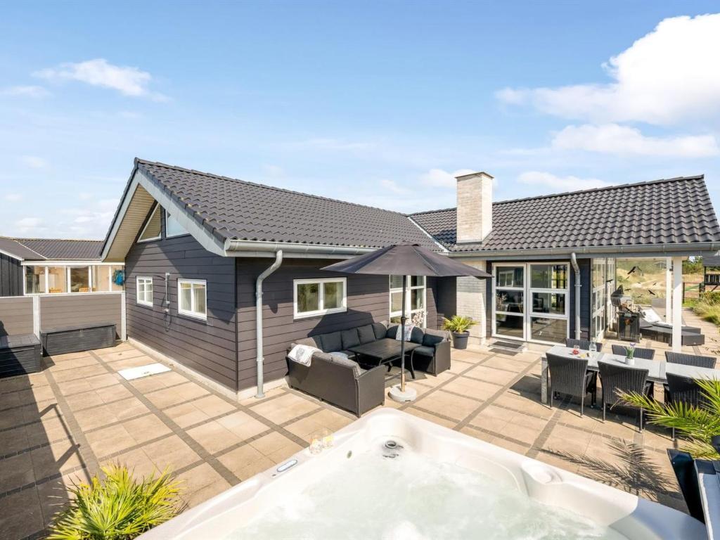 a house with a patio with a hot tub at Holiday Home Ennie - from the sea by Interhome in Bjerregård