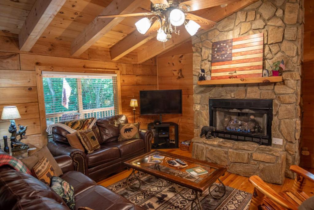 un soggiorno con divano e camino di Updated Cabin with 2 primary suites, hot tub, spacious covered porch a Fleetwood