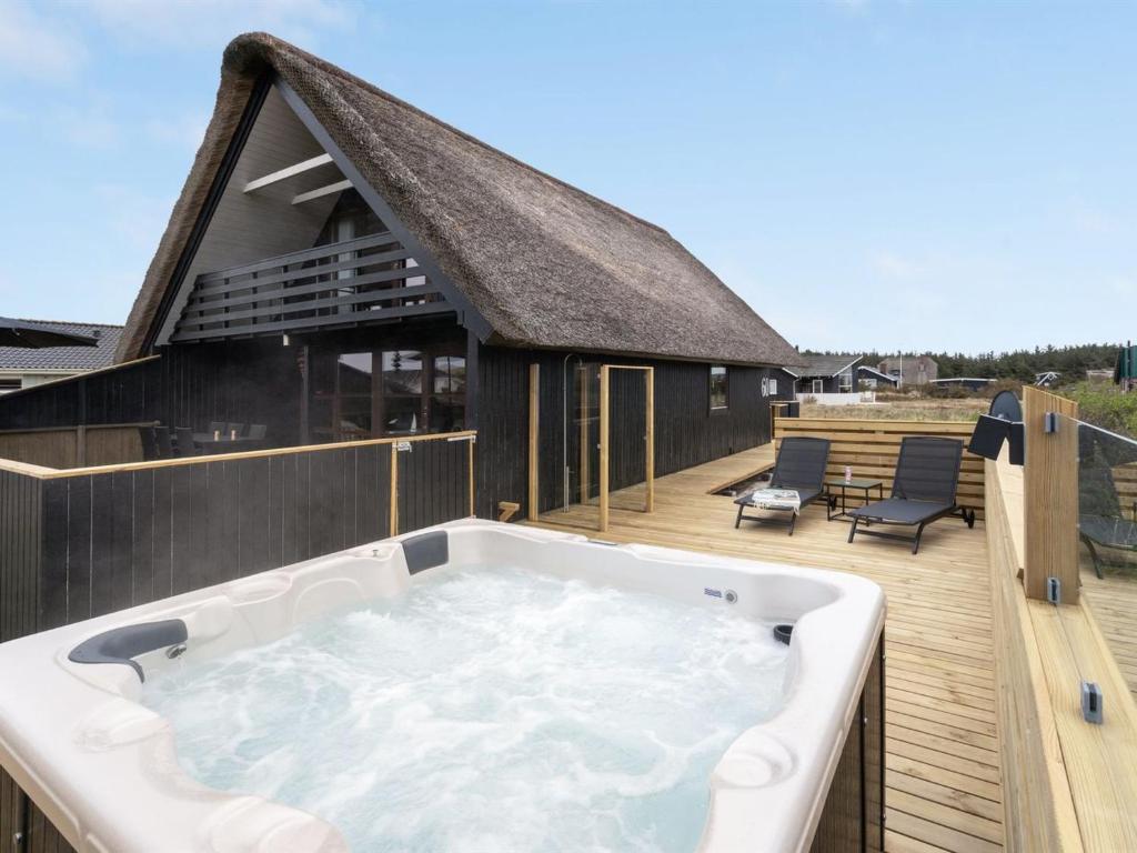 a hot tub on the deck of a house at Holiday Home Kristanna - 150m from the sea by Interhome in Harboør