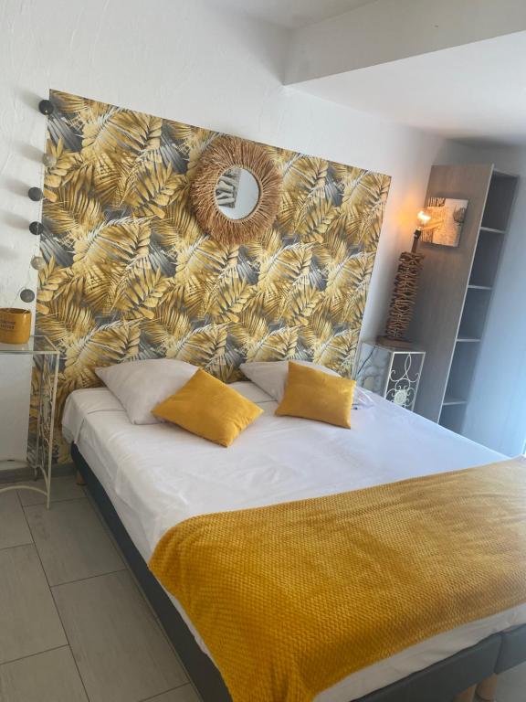 a bed with two yellow pillows in a bedroom at BAS DE VILLA, Mer Piscine et SPA in Roquebrune-sur-Argens