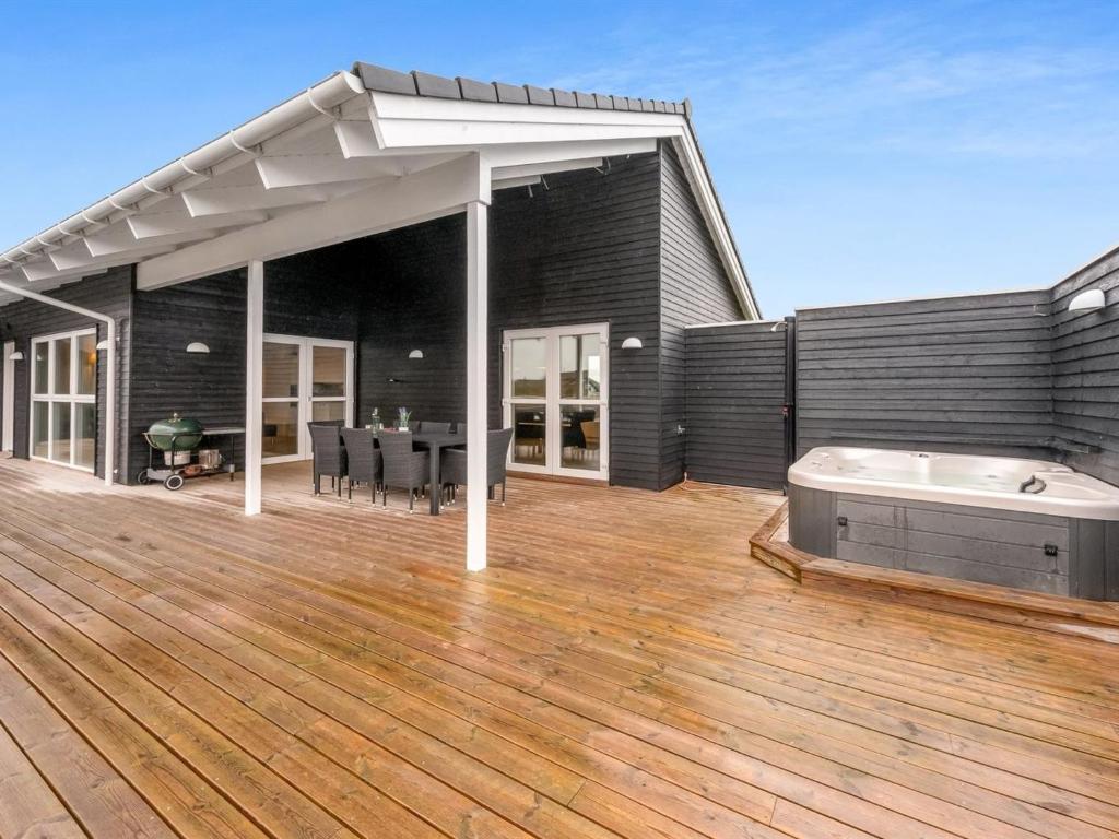 une grande terrasse avec un bain à remous dans une maison dans l'établissement Holiday Home Markku - 400m from the sea by Interhome, à Harboør