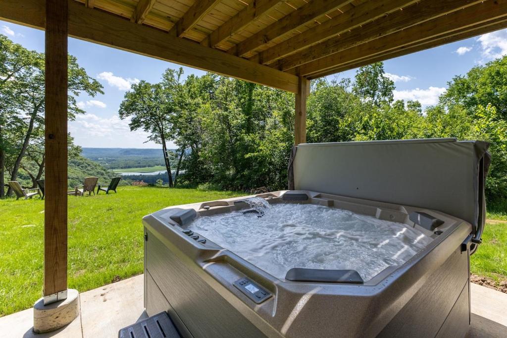 a hot tub on a patio with a view of a field at Diamond in the Bluff - HOT TUB - Sleeps 6 in De Soto