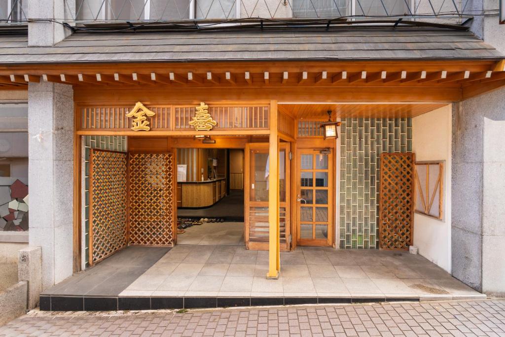 - une entrée pour un bâtiment avec des portes en bois dans l'établissement Kaneki Hotel, à Yamanouchi