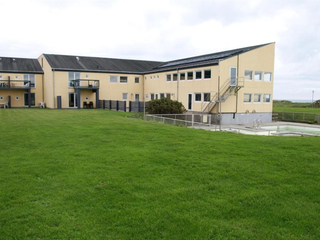 a large grass field in front of a building at Apartment Lenya - 150m from the sea by Interhome in Løkken