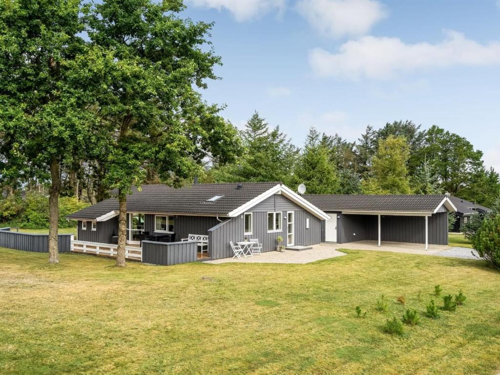 a gray house with a large yard at Holiday Home Dimo - 700m from the sea by Interhome in Løkken