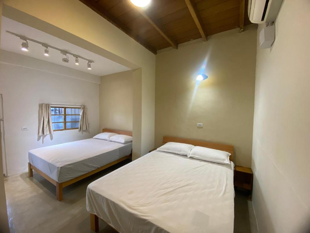 a bedroom with two beds and a window at 吉細廊 in Changhua City