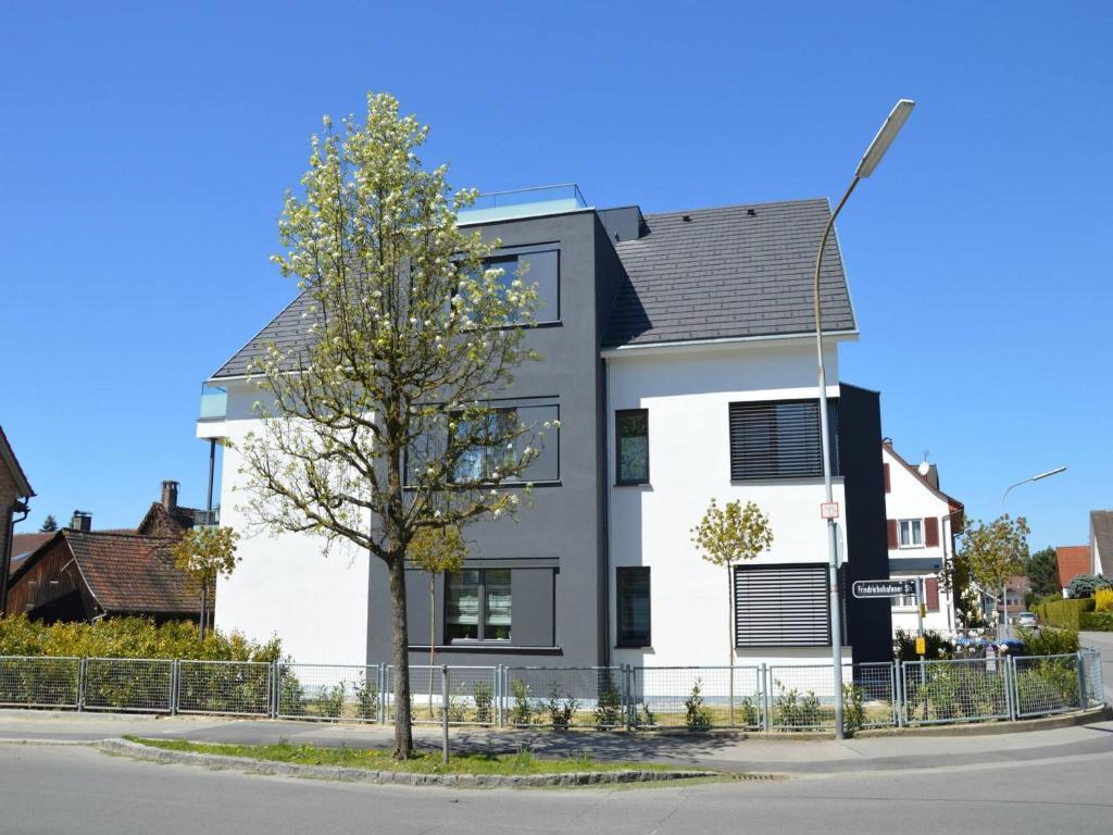 ein weißes und schwarzes Haus mit einem Baum davor in der Unterkunft Kapps Haus in Langenargen