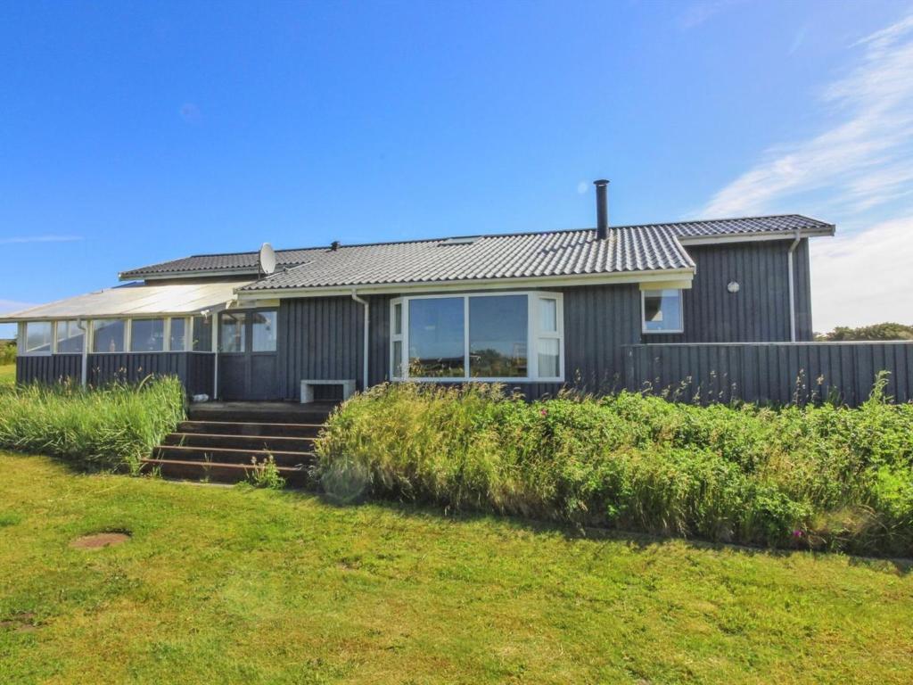 a house with a fence and a yard at Holiday Home Marne - 500m from the sea by Interhome in Løkken