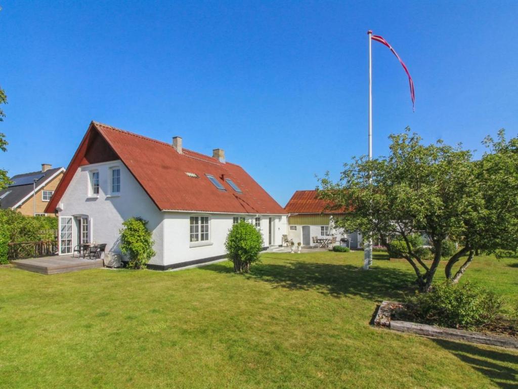 a white house with a flag pole in a yard at Holiday Home Fraþulf - 6km from the sea by Interhome in Løkken