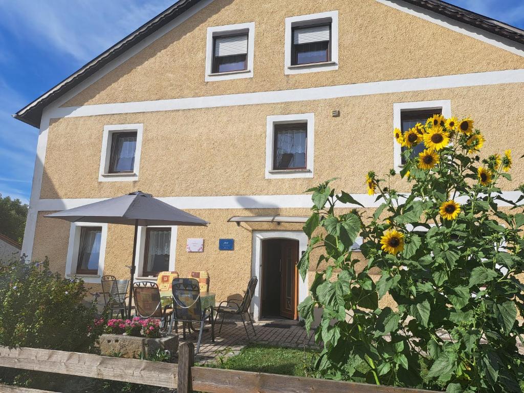 a house with sunflowers in front of it at Gästehaus Ulrike in Steinberg am See