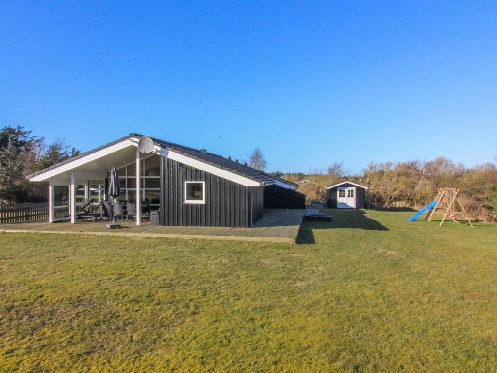a house with a large yard with a playground at Holiday Home Nynke - 600m from the sea by Interhome in Løkken