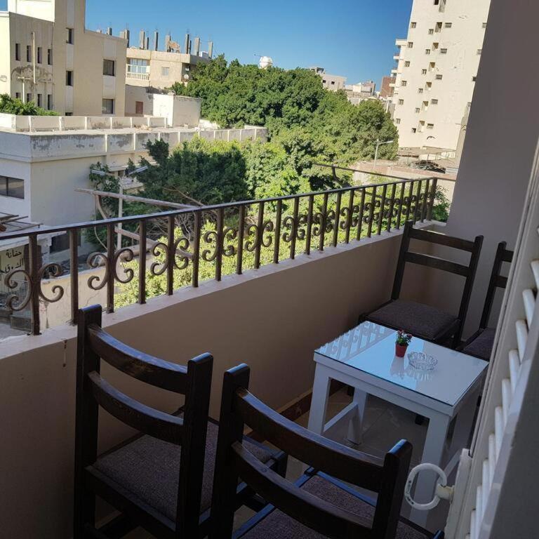 a balcony with two chairs and a table on a balcony at Sweet Home Hostel - ممنوع للبنات فى الوقت الحالى in Hurghada