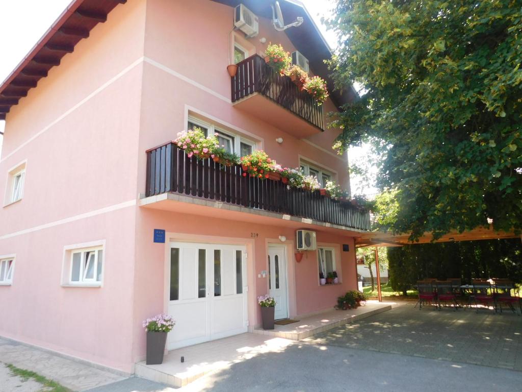 una casa rosa con flores en los balcones en House Vukovic en Grabovac