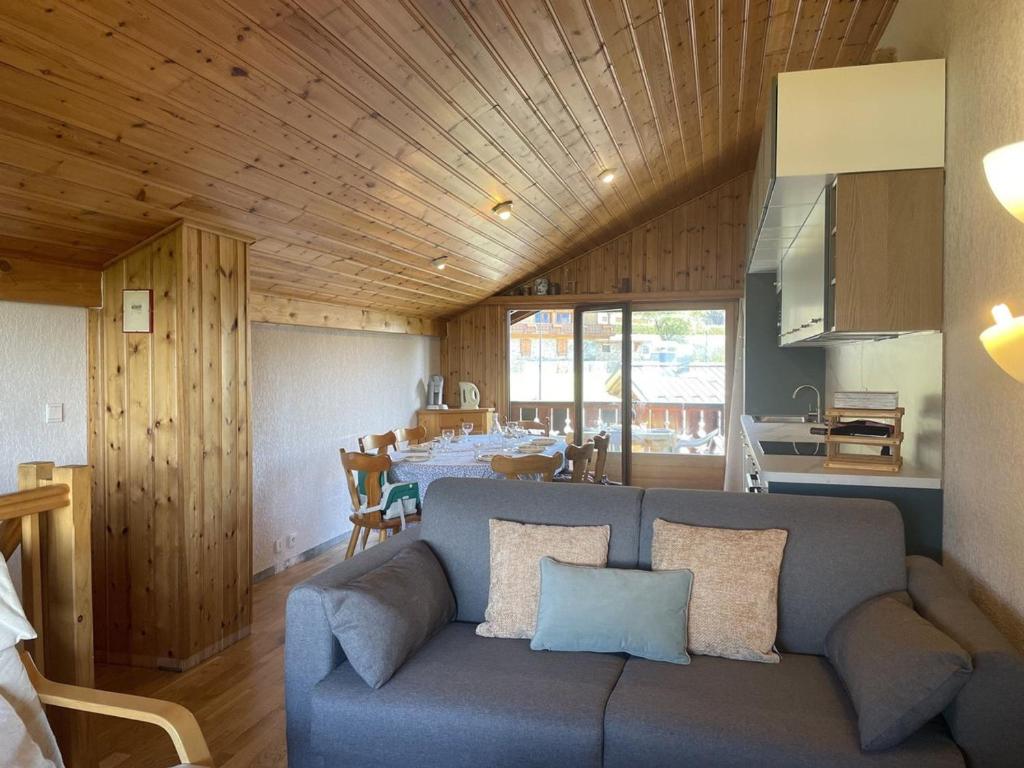 ein Wohnzimmer mit einer blauen Couch und einer Küche in der Unterkunft Duplex lumineux 3 pièces, 7 pers, 3 balcons, proche pistes et commerces, parking, ski bus - FR-1-572-72 in Arâches-la-Frasse