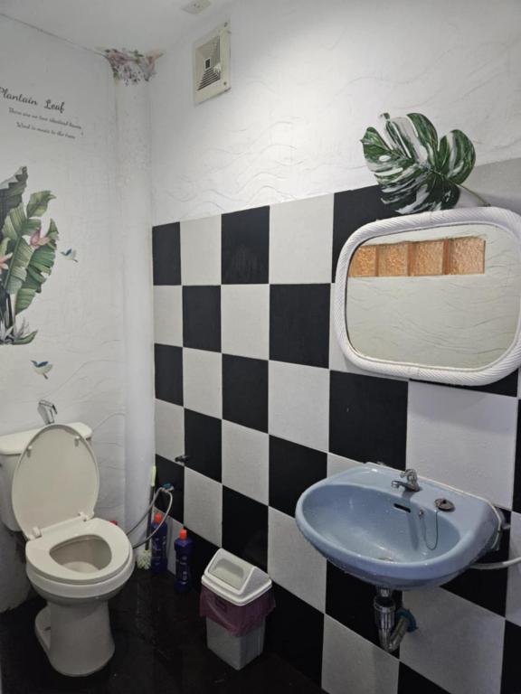 a bathroom with a black and white checkered wall at Af พลูวิลล่า in Na Jomtien
