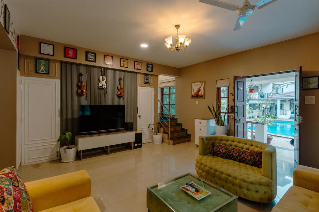 a living room with a couch and a television at 2 bedroom perfect stay villas in Anjuna