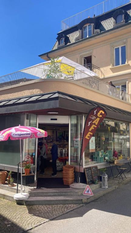 a store with an umbrella in front of a building at Organic BnB Froschkoenig Chaiserstock in Gersau