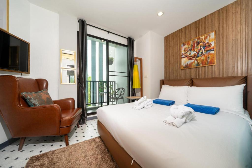une chambre avec un lit avec une chaise et une télévision dans l'établissement Zcape1 apartment at Boat Avenue by Lofty, à Ban Thalat Choeng Thale