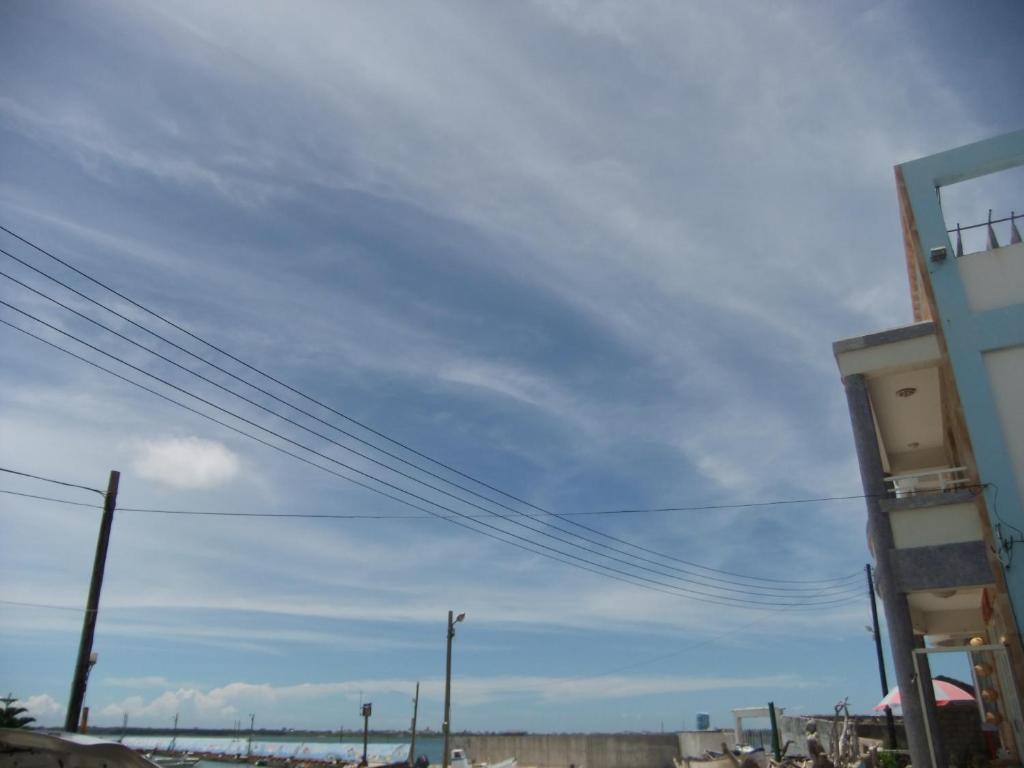 a blue sky with power lines in front of a building at Sea Front Homestay in Magong