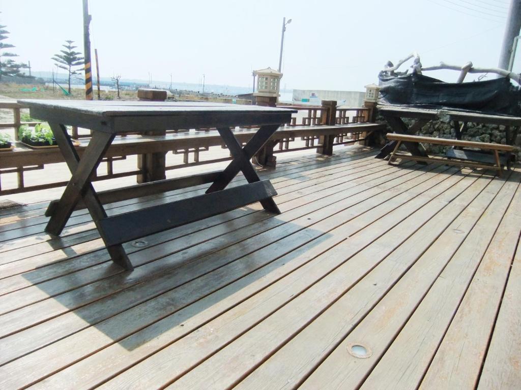 a picnic table on the deck of a boat at Sea Front Homestay in Magong